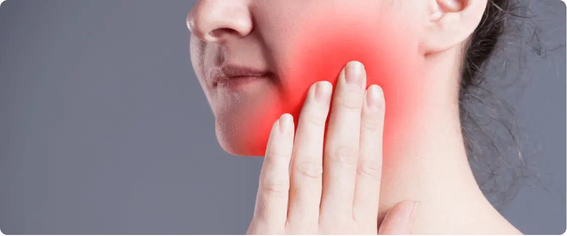Woman holding cheek in dental pain
